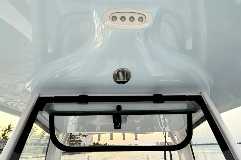 Slide: The Image of 2024 Sea Hunt Ultra 265 SE boat interior with overhead lighting and window view. - 10