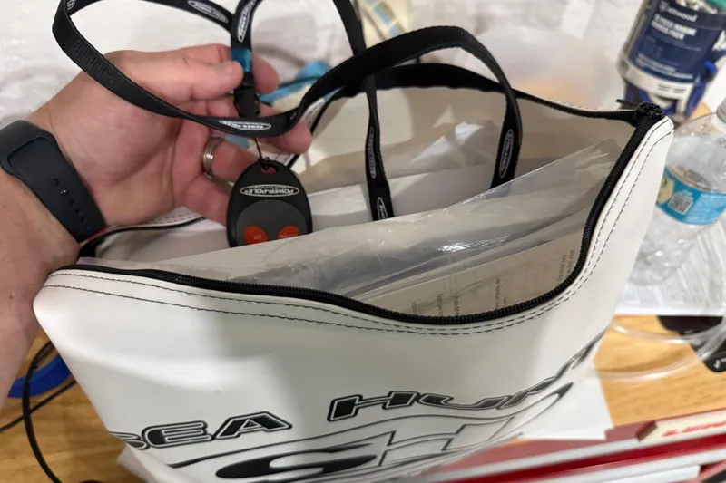 Slide: The Image of Hand holding a remote above a Sea Hunt Ultra 265 SE bag, 2024 model. - 11