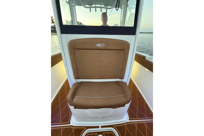 Slide: The Image of 2024 Sea Hunt Ultra 265 SE boat interior with brown cushioned seating. - 14