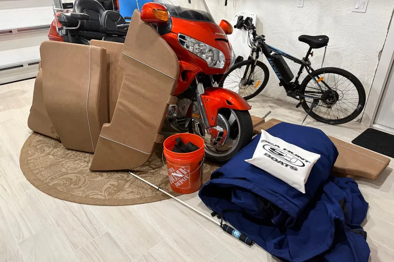 Slide: The Image of A garage with motorcycle, bicycle, and Sea Hunt Ultra 265 SE boat accessories. - 16