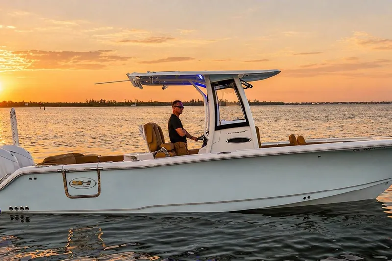 Slide: The Image of 2024 Sea Hunt Ultra 265 SE boat cruising at sunset on calm waters. - 2
