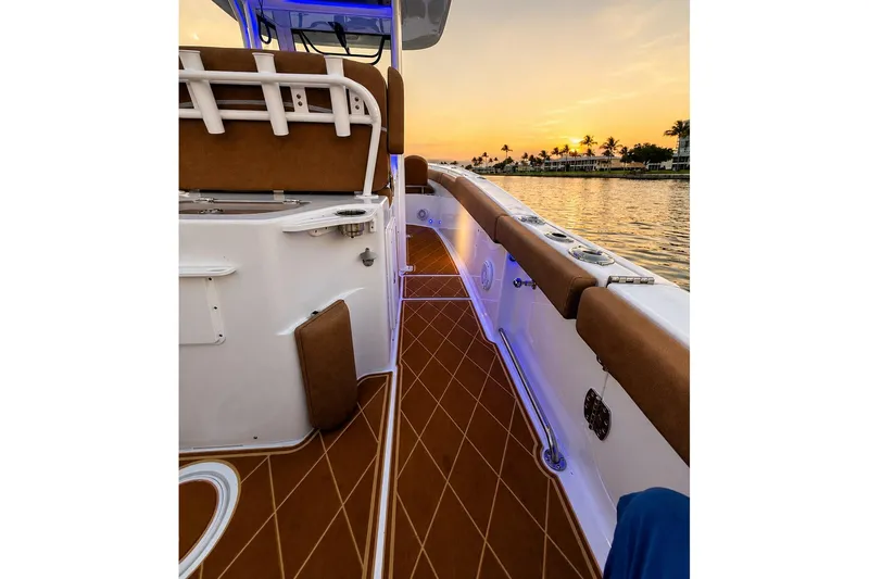 Slide: The Image of 2024 Sea Hunt Ultra 265 SE boat interior at sunset, featuring elegant seating and deck design. - 21
