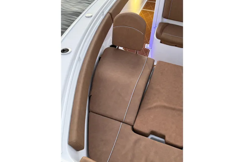 Slide: The Image of 2024 Sea Hunt Ultra 265 SE boat interior with brown cushioned seating. - 24