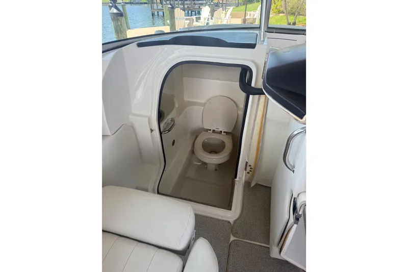 Slide: The Image of 2024 Sea Hunt Ultra 265 SE boat interior with compact marine toilet. - 26