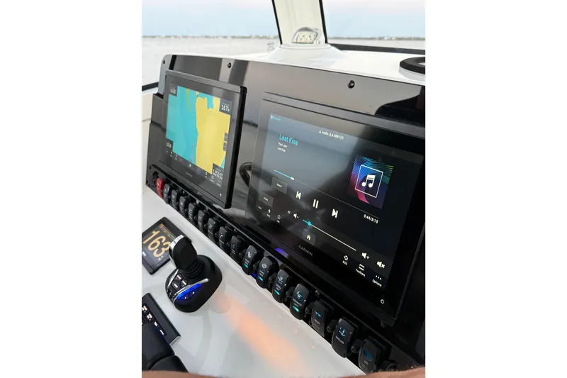 Slide: The Image of Dashboard of 2024 Sea Hunt Ultra 265 SE with navigation and audio displays. - 31