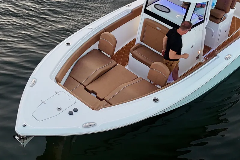 Slide: The Image of 2024 Sea Hunt Ultra 265 SE boat with tan seating on calm water. - 33