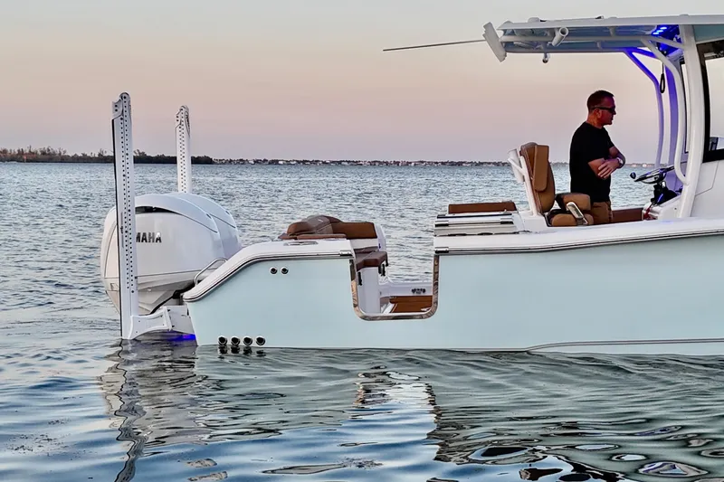 Slide: The Image of 2024 Sea Hunt Ultra 265 SE boat on calm water at sunset. - 39