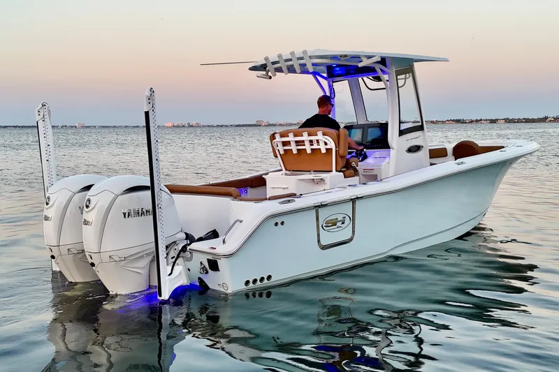 Slide: The Image of 2024 Sea Hunt Ultra 265 SE boat on calm water at sunset. - 4