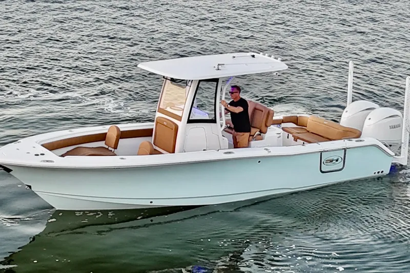 Slide: The Image of 2024 Sea Hunt Ultra 265 SE boat cruising on water with a person at the helm. - 45