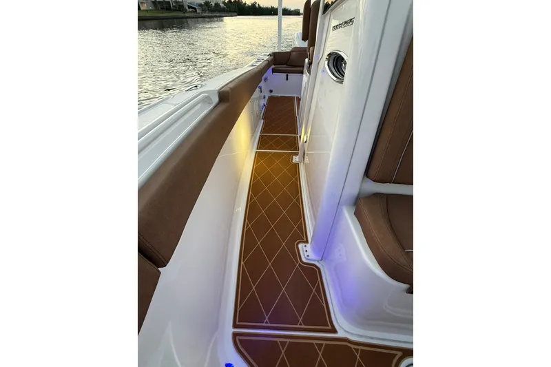 Slide: The Image of 2024 Sea Hunt Ultra 265 SE boat interior with brown seating and illuminated flooring. - 47