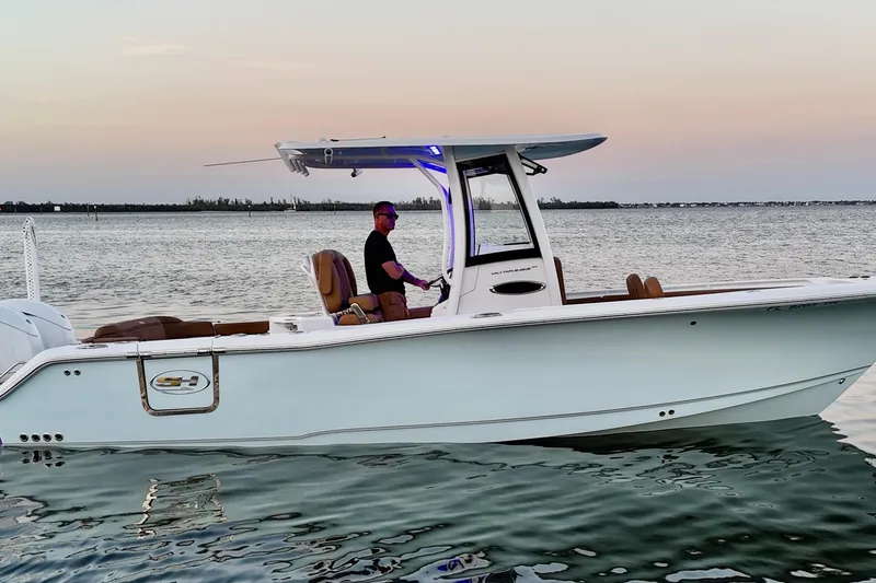 Slide: The Image of 2024 Sea Hunt Ultra 265 SE boat on calm water at sunset. - 49