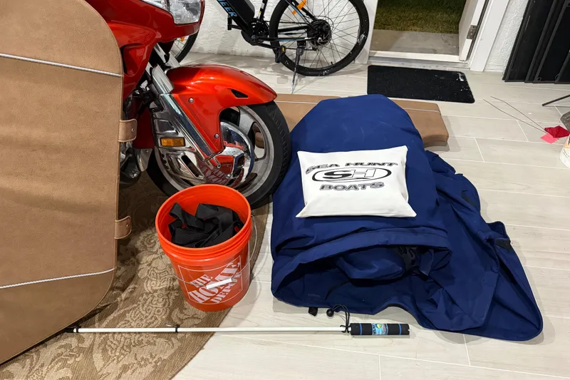 Slide: The Image of Garage scene with Sea Hunt Ultra 265 SE cover, motorcycle, and Home Depot bucket. - 54