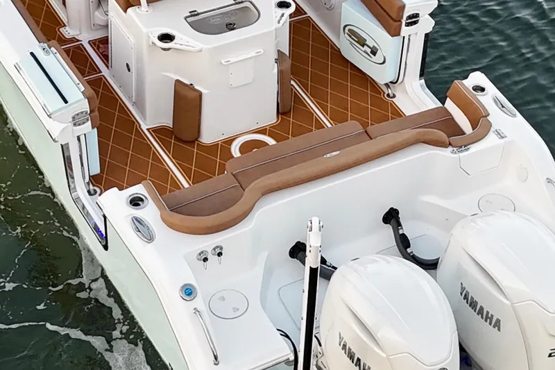 Slide: The Image of 2024 Sea Hunt Ultra 265 SE boat interior with Yamaha engines, featuring brown seating and deck. - 57