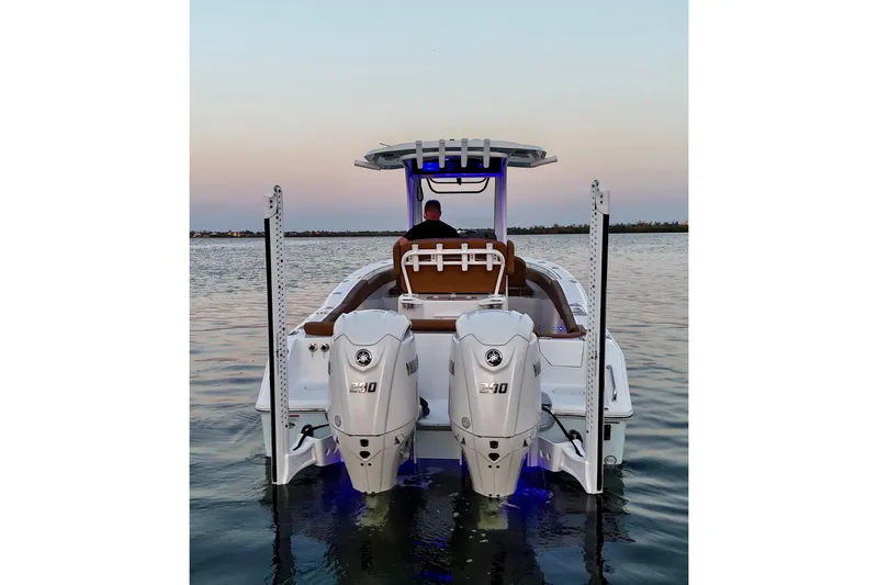 Slide: The Image of 2024 Sea Hunt Ultra 265 SE boat with dual Yamaha engines on calm water at sunset. - 58