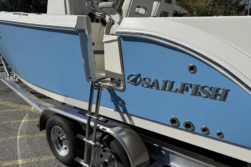 Slide: The Image of 2026 Sailfish 252 CC boat on trailer, featuring blue and white design. - 14