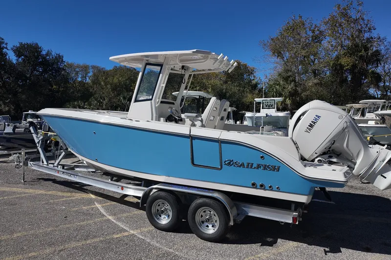 Slide: The Image of 2026 Sailfish 252 CC boat on trailer with Yamaha engine, parked outdoors. - 2