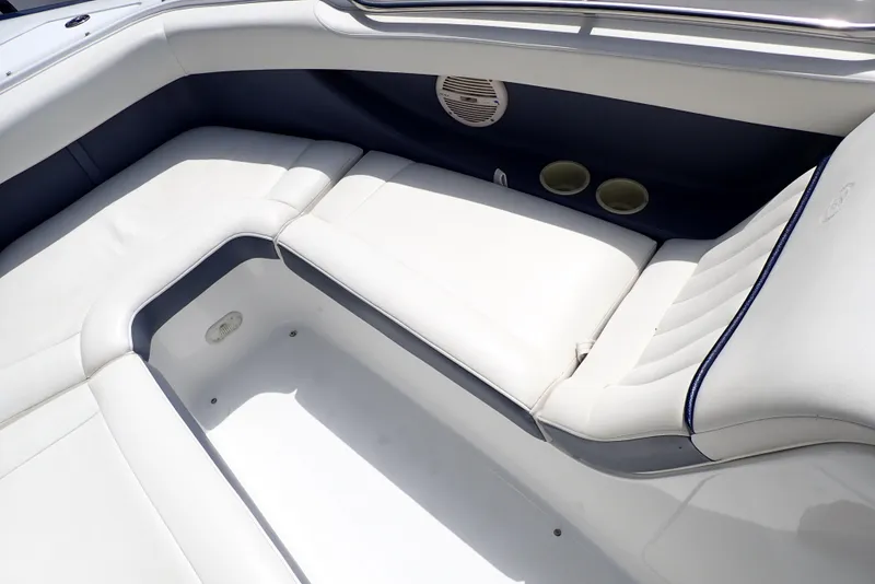 Slide: The Image of Interior seating of a 2002 Cobalt 240 boat, featuring white upholstery and cup holders. - 23
