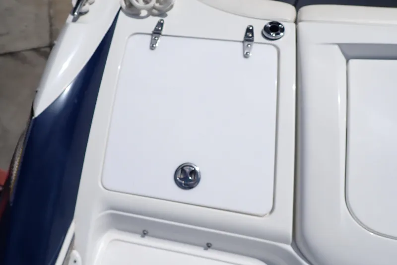Slide: The Image of 2002 Cobalt 240 boat deck with storage compartment and latch. - 27