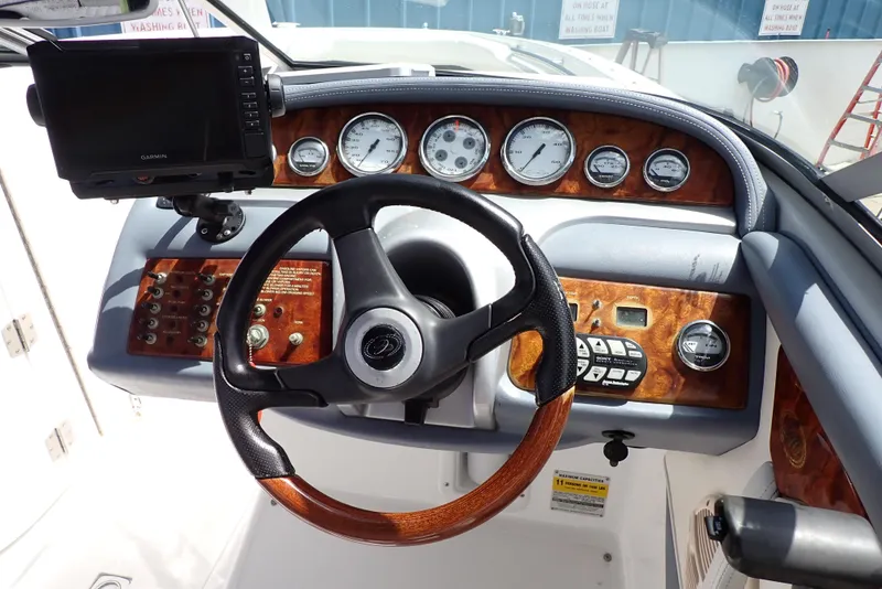 Slide: The Image of Steering wheel and dashboard of a 2002 Cobalt 240 boat with wood accents. - 6