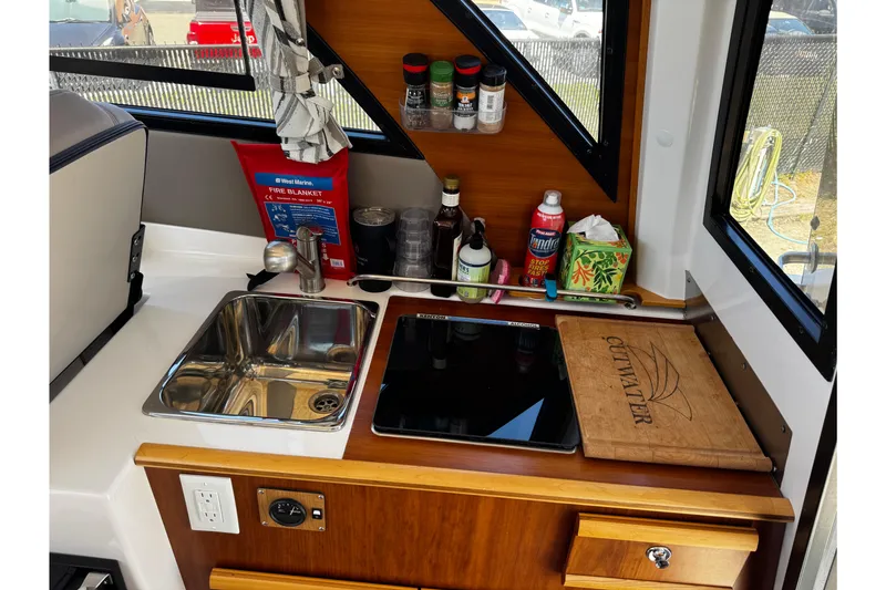 Slide: The Image of 2022 Cutwater C-248 Coupe interior kitchen with sink, stove, and storage. - 19