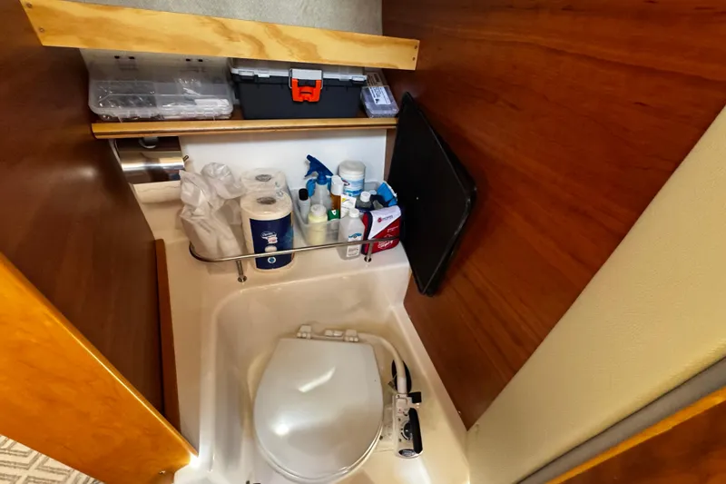 Slide: The Image of 2022 Cutwater C-248 Coupe bathroom with toilet, cleaning supplies, and storage shelves. - 23