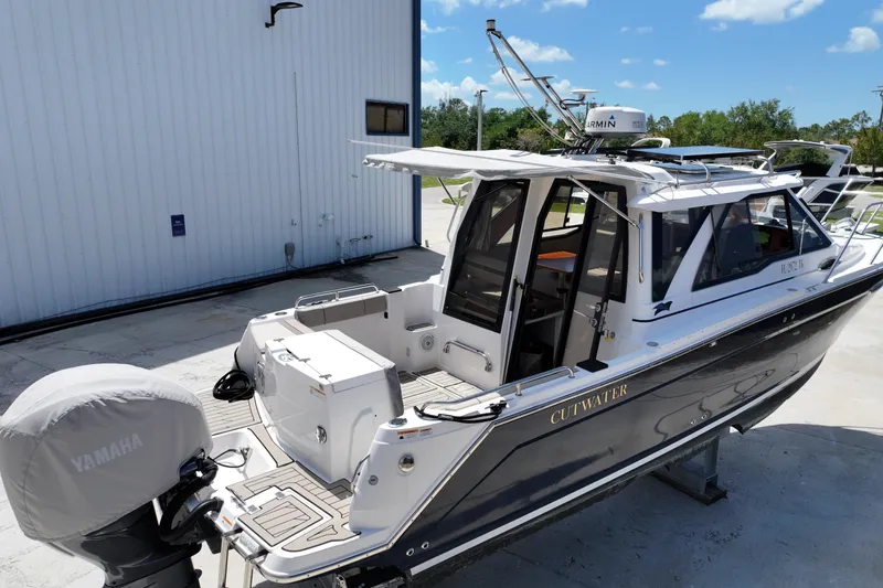 Slide: The Image of 2022 Cutwater C-248 Coupe boat with Yamaha engine, docked outdoors under clear blue sky. - 3