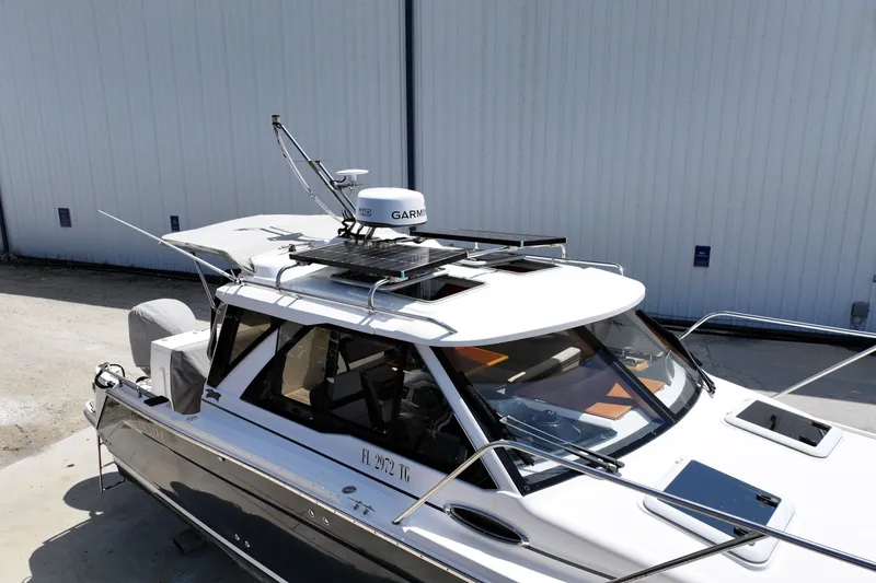 Slide: The Image of 2022 Cutwater C-248 Coupe boat with Garmin radar, docked near a white building. - 4