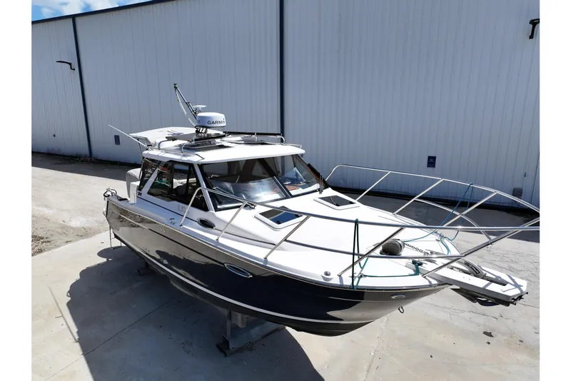 Slide: The Image of 2022 Cutwater C-248 Coupe boat docked outdoors, featuring sleek design and Garmin equipment. - 5