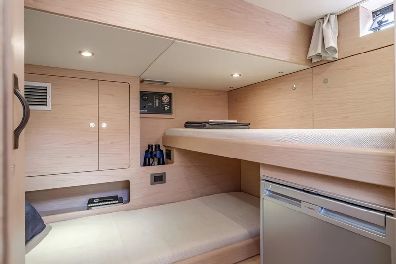 Slide: The Image of Interior cabin of 2022 Beneteau Grand Trawler 62 with bunk beds and storage. - 8