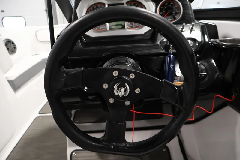 Slide: The Image of Steering wheel and dashboard of 2021 Scarab 215 ID boat, featuring gauges and controls. - 19