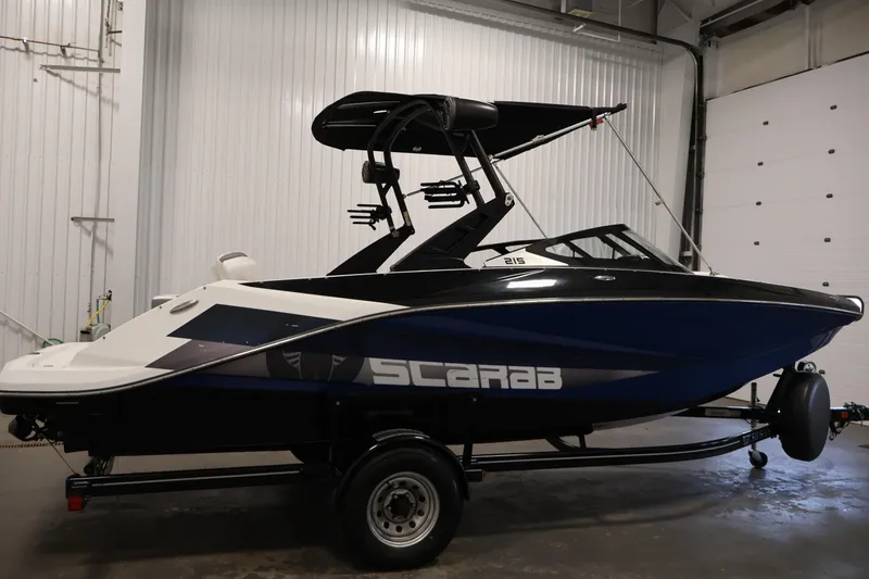 Slide: The Image of 2021 Scarab 215 ID boat in a garage, featuring sleek design and modern features. - 3