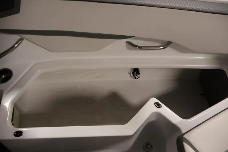 Slide: The Image of Interior storage compartment of 2021 Scarab 215 ID boat, featuring sleek design and metal handle. - 37