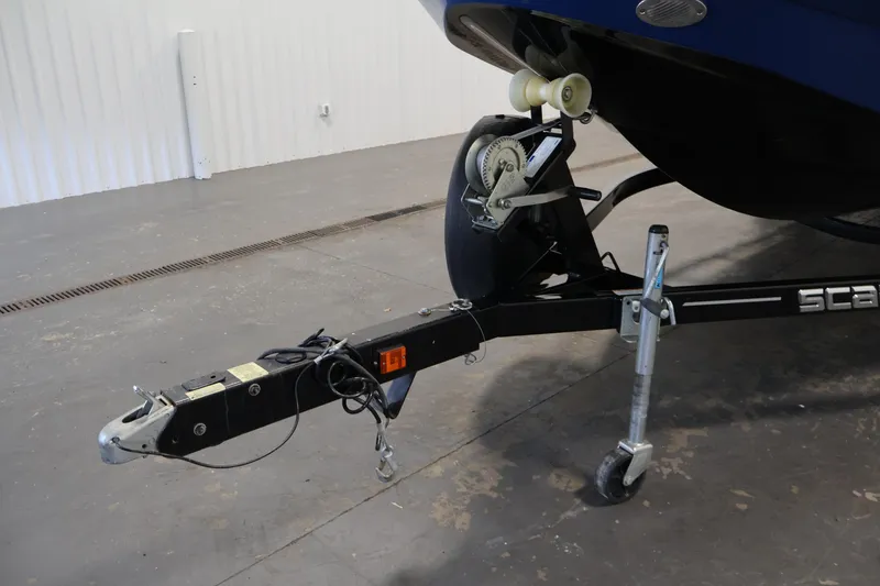 Slide: The Image of Trailer hitch of a 2021 Scarab 215 ID boat in a garage setting. - 44