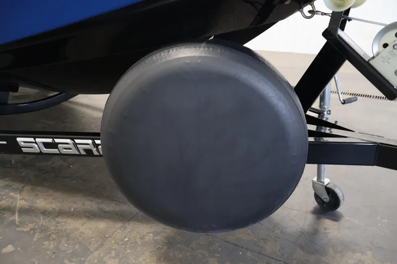Slide: The Image of Trailer wheel of a 2021 Scarab 215 ID boat, shown in a garage setting. - 45