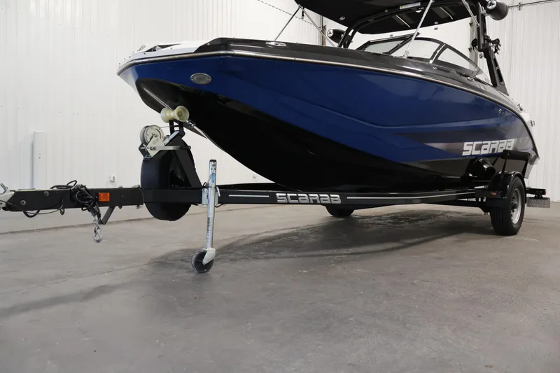 Slide: The Image of 2021 Scarab 215 ID boat on trailer in indoor setting. - 46
