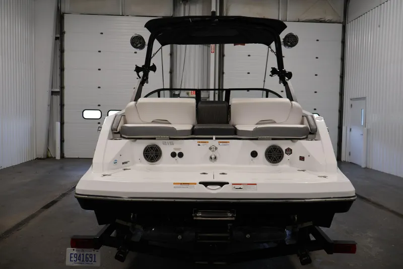 Slide: The Image of 2021 Scarab 215 ID boat in a garage, rear view with seating and speakers. - 5