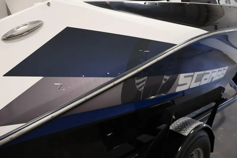 Slide: The Image of 2021 Scarab 215 ID boat side view with sleek design and logo. - 50