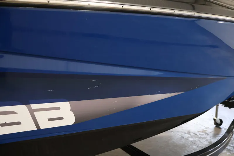 Slide: The Image of Blue 2021 Scarab 215 ID boat hull with visible scratches. - 51