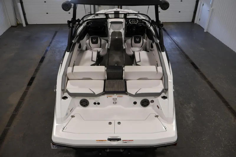 Slide: The Image of 2021 Scarab 215 ID boat interior with white seating and modern design in a garage setting. - 9