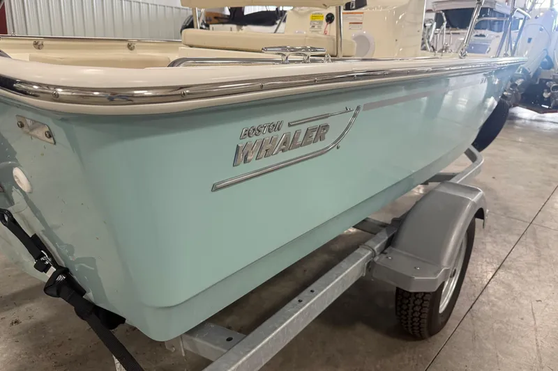 Slide: The Image of 2023 Boston Whaler 150 Montauk boat on trailer in indoor storage. - 3