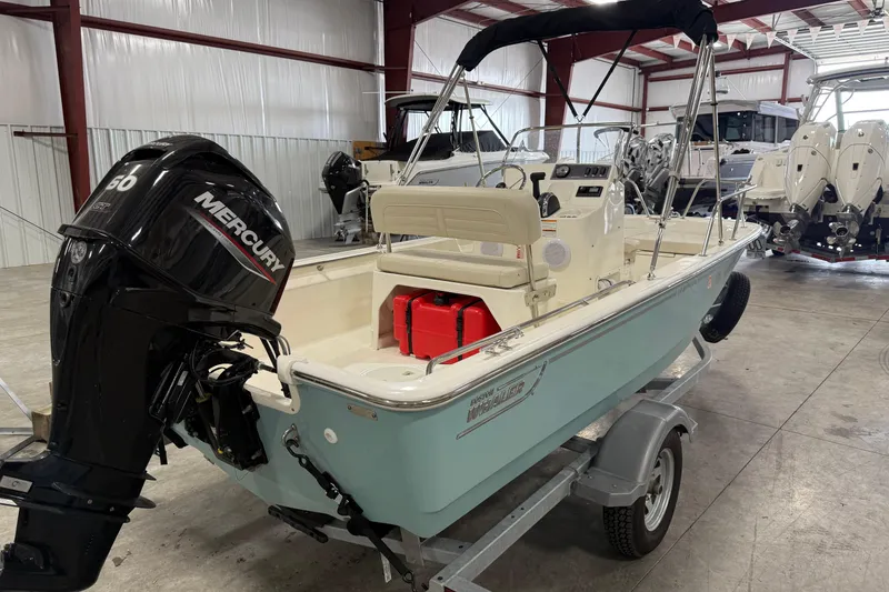 Slide: The Image of 2023 Boston Whaler 150 Montauk boat with Mercury engine in showroom. - 5
