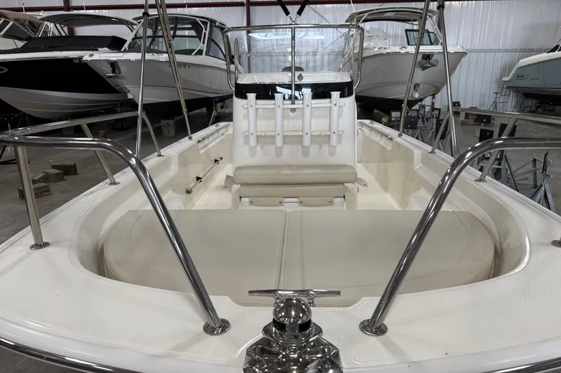 Slide: The Image of 2023 Boston Whaler 150 Montauk boat interior with seating and railings in a showroom. - 7