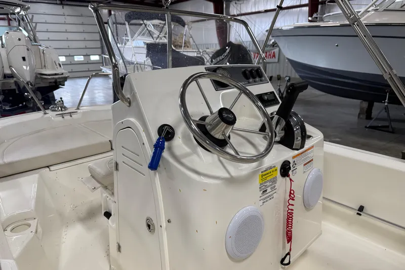 Slide: The Image of 2023 Boston Whaler 150 Montauk boat interior with steering wheel and control panel. - 8