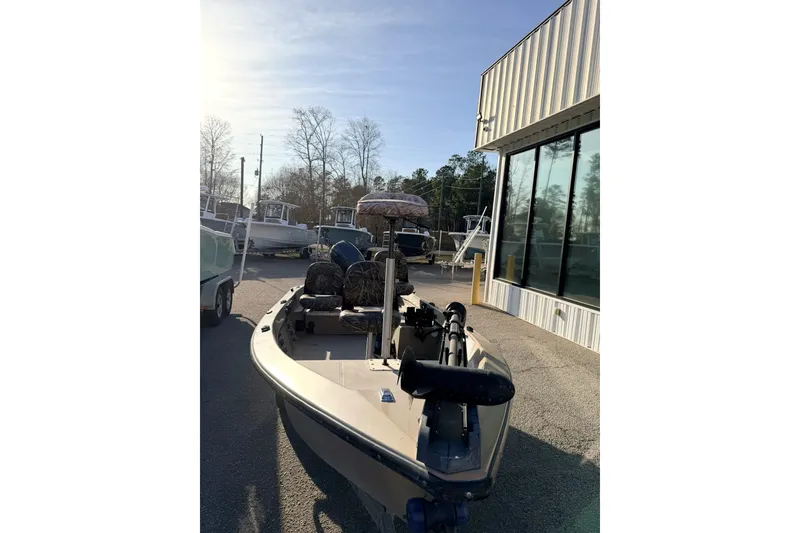 Slide: The Image of 2006 HIGH TIDE 15 boat parked outside a building under clear skies. - 12