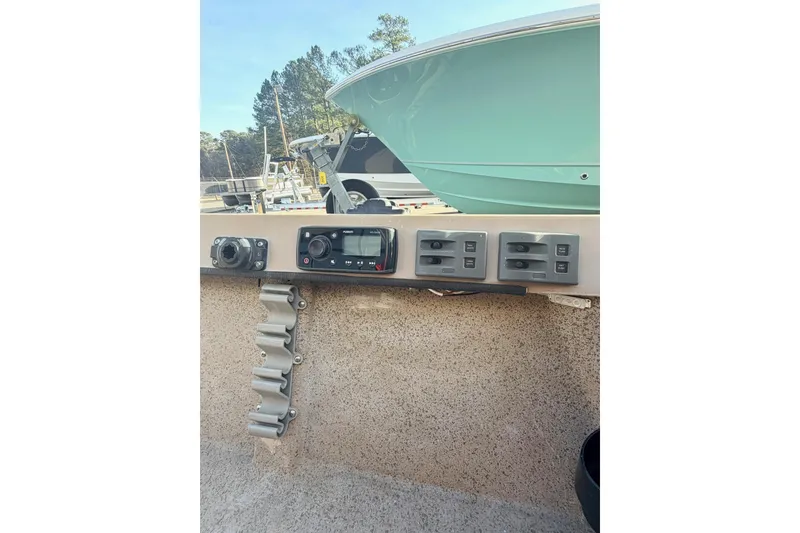 Slide: The Image of Control panel of a 2006 HIGH TIDE 15 boat with switches and radio. - 16