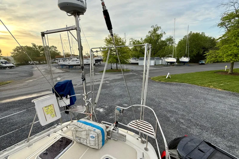 Slide: The Image of 2001 Caliber 47LRC sailboat on land, surrounded by other boats and greenery. - 12