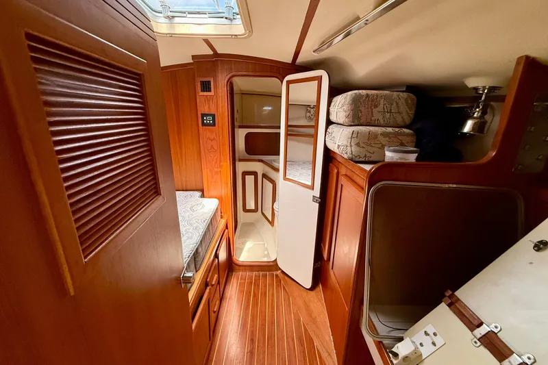 Slide: The Image of Interior of 2001 Caliber 47LRC yacht with wooden finishes and cozy sleeping area. - 16