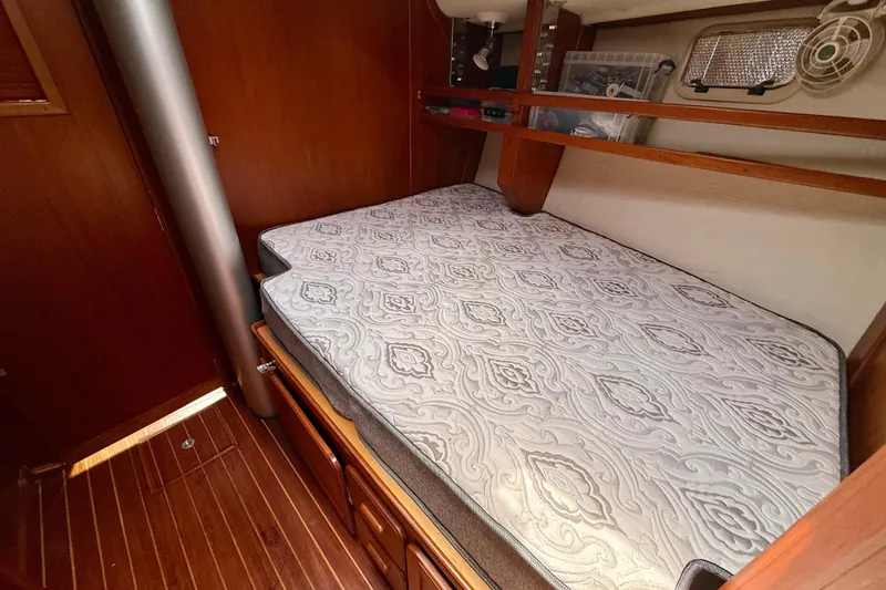 Slide: The Image of Cozy cabin interior of 2001 Caliber 47LRC yacht with patterned mattress and wooden accents. - 17