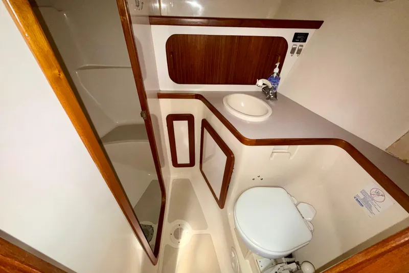 Slide: The Image of Bathroom interior of 2001 Caliber 47LRC yacht, featuring sink, toilet, and wooden accents. - 18