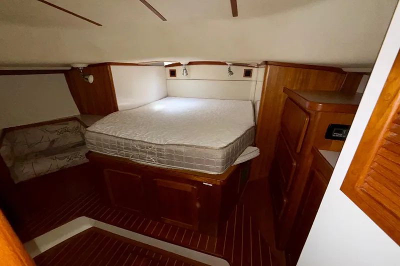 Slide: The Image of Cozy cabin interior of 2001 Caliber 47LRC yacht with wooden furnishings and bed. - 19